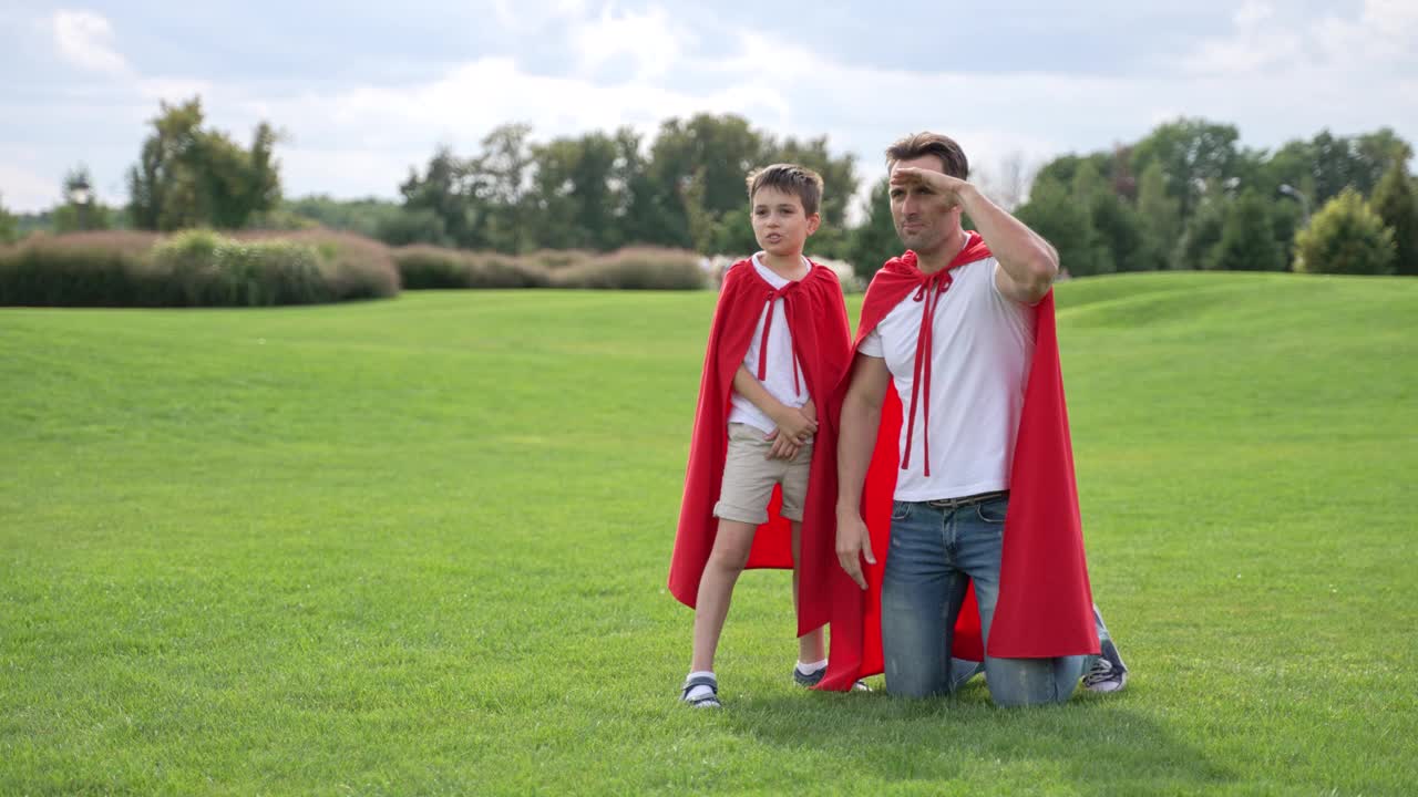 爸爸和儿子打扮成超级英雄在户外玩耍视频下载