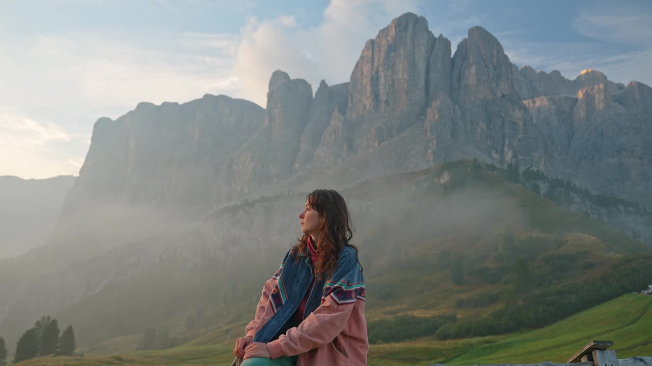 女人坐在谷加迪纳尖峰山脉的背景上视频下载