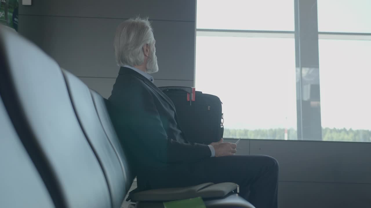 在机场候机楼等候的资深商人视频下载
