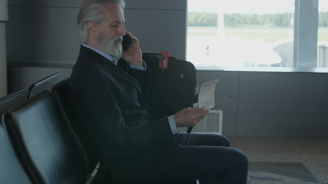 资深商人在机场候机楼打电话视频下载