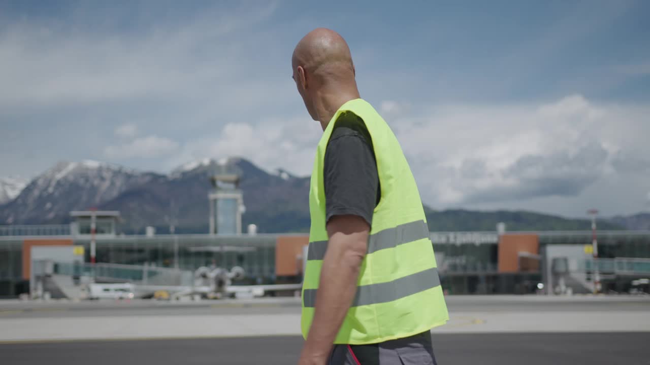 机场地勤人员走在停机坪上视频下载