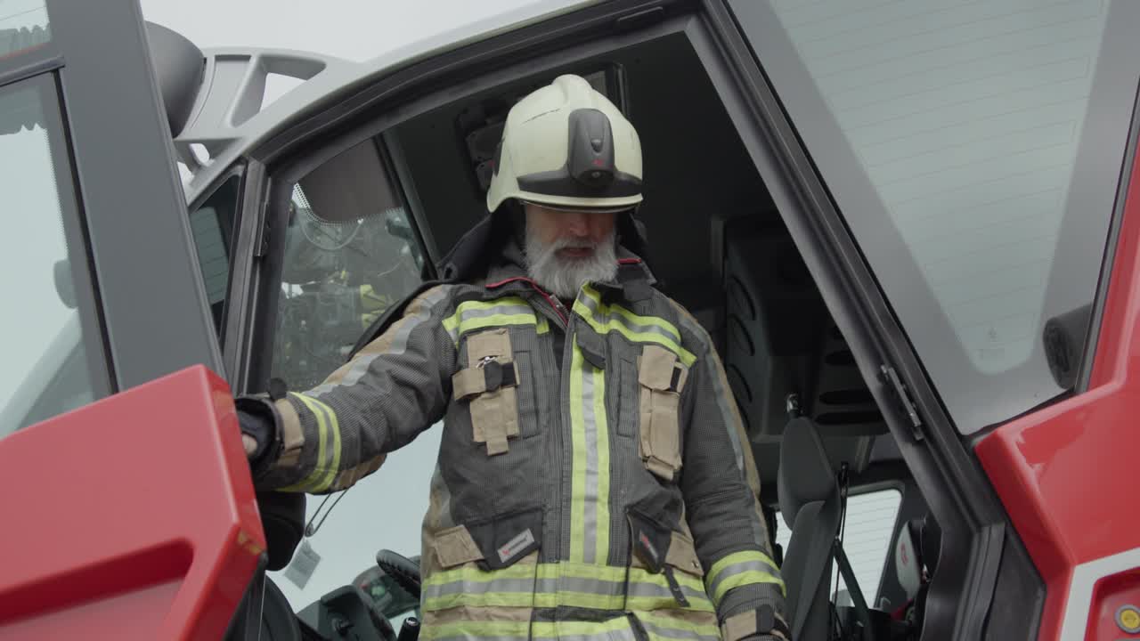 高级消防员从机场的消防车里出来视频下载