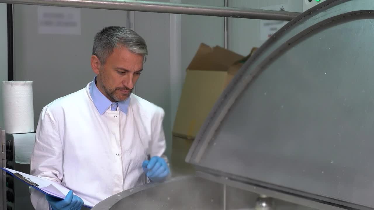 监督原料奶巴氏杀菌过程的食品安全和质量技术员-放大镜头视频下载