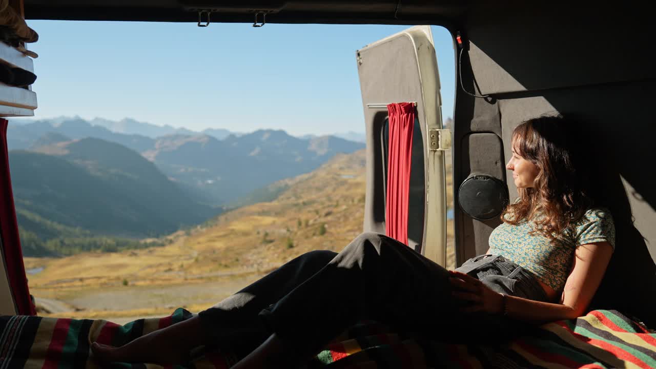一个女人躺在露营车的床上看山视频下载