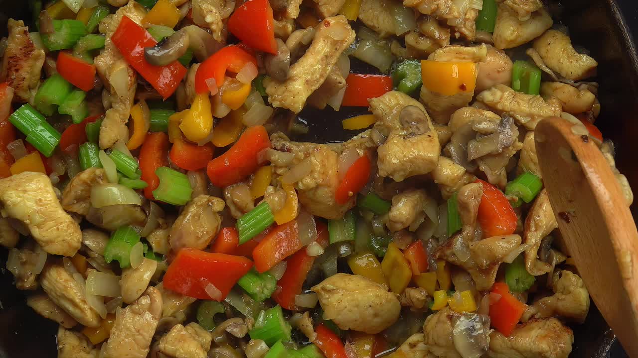 用锅铲搅拌鸡肉、蔬菜和蘑菇碎视频下载