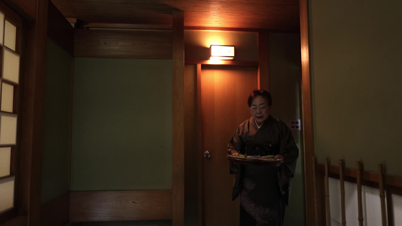 资深餐厅老板在传统的日本餐厅里上菜视频下载