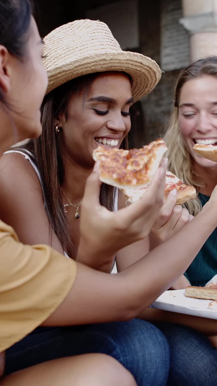 三个快乐的多种族年轻女人在街上吃披萨视频下载