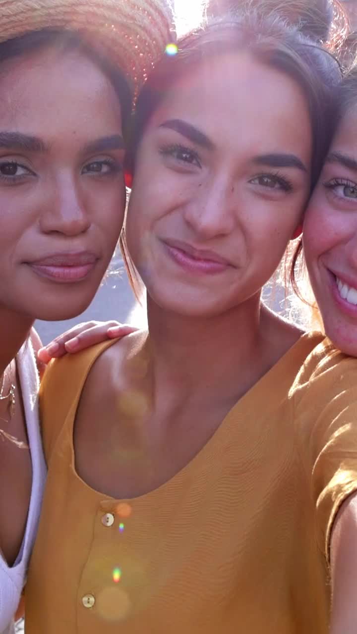 三位团结多样的年轻女性朋友一起对着镜头微笑视频下载