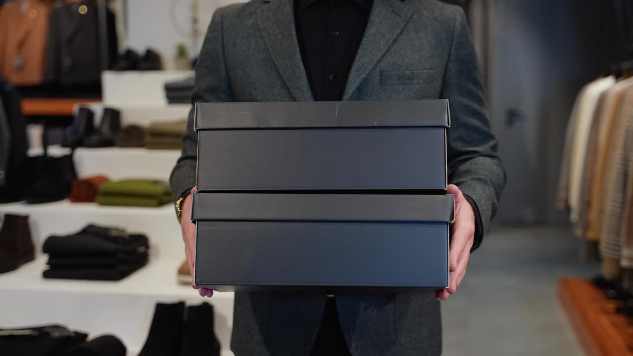 一个拿着鞋盒在服装店的男人视频下载