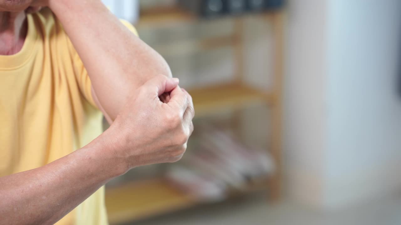 一个亚洲老人身体疼痛的特写视频。肌肉疼痛无力，手臂和脚踝疼痛保健概念视频下载