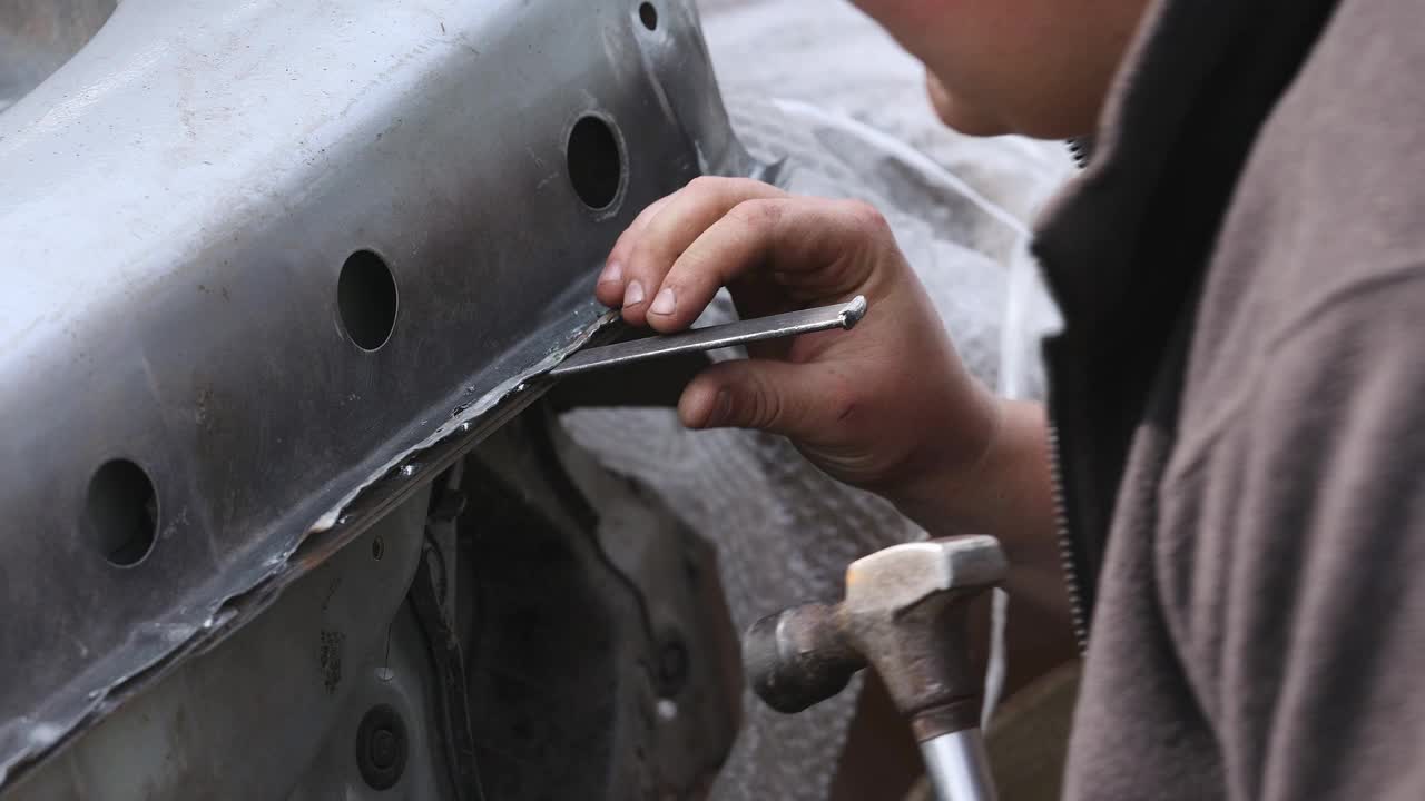 机械师用锤子和凿子加工金属。视频下载