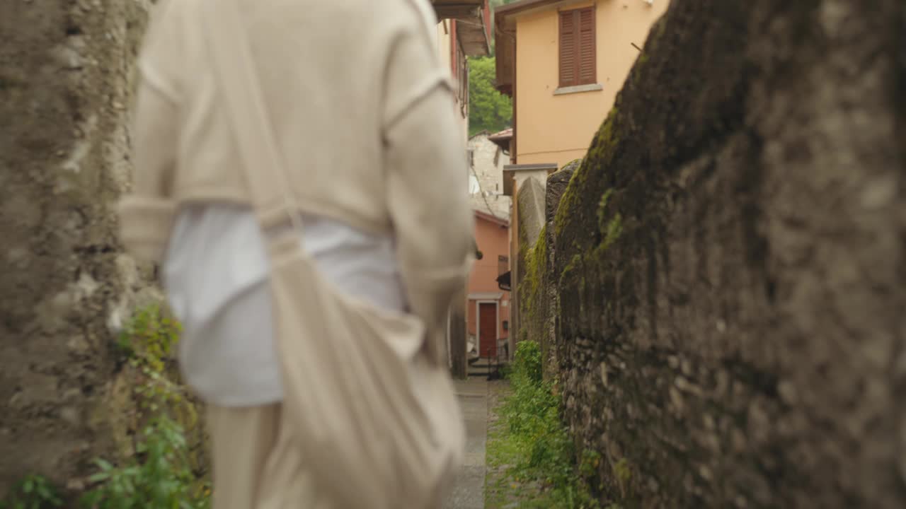 一个女人在意大利的一个村庄里散步和探索视频下载