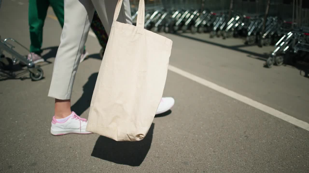 无法辨认的女士推着购物车，同时使用可重复使用的购物袋视频下载