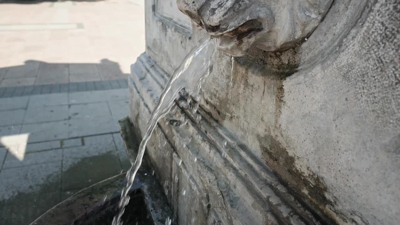一个不知名的女人在给金属水瓶装水，瓶子里装的是老城喷泉里的水视频下载