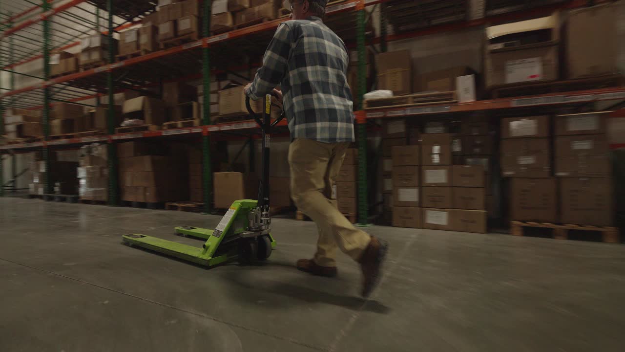 仓库工人用托盘千斤顶搬运货物/美国犹他州美国福克视频下载