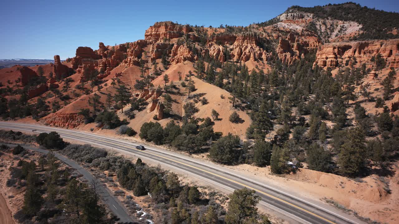 在沙漠风景公路上行驶的汽车鸟瞰图/美国犹他州布莱斯峡谷视频下载