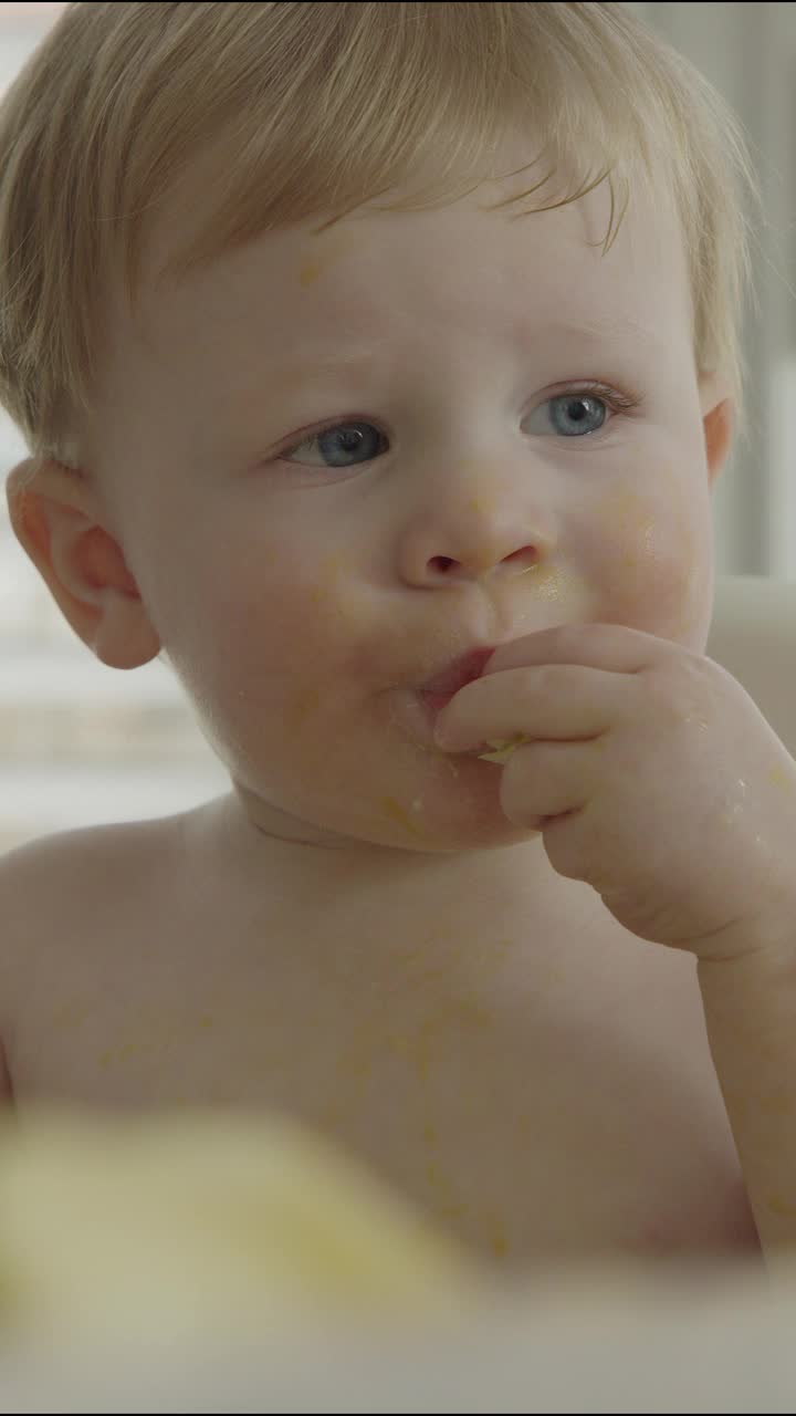 在椅子上吃食物的严重婴儿的特写-垂直视频/雪松山，犹他州，美国视频下载