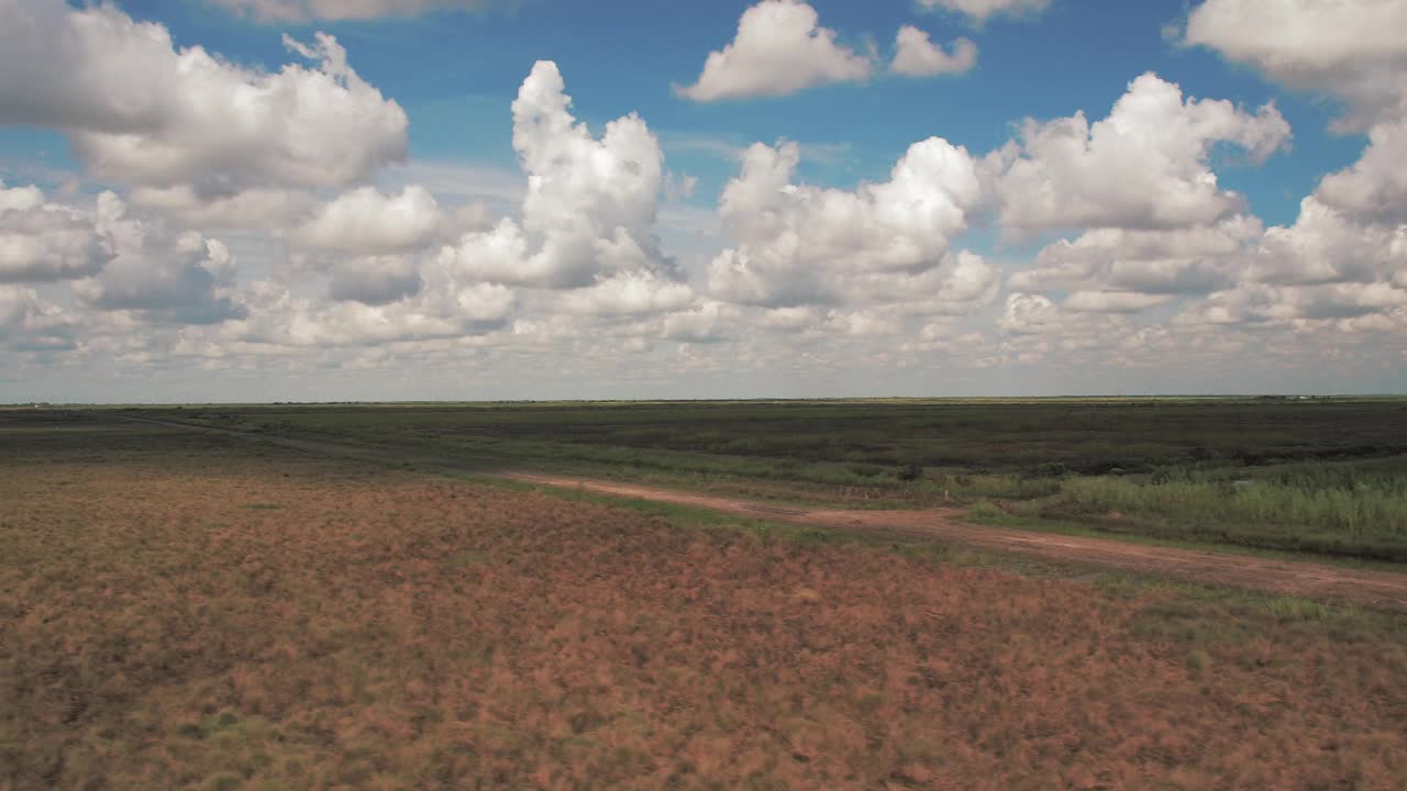 在晴朗的日子里，在多云的天空下，干燥的植物在宁静的景观上的航拍风景- Bayou Vista，德克萨斯州视频下载