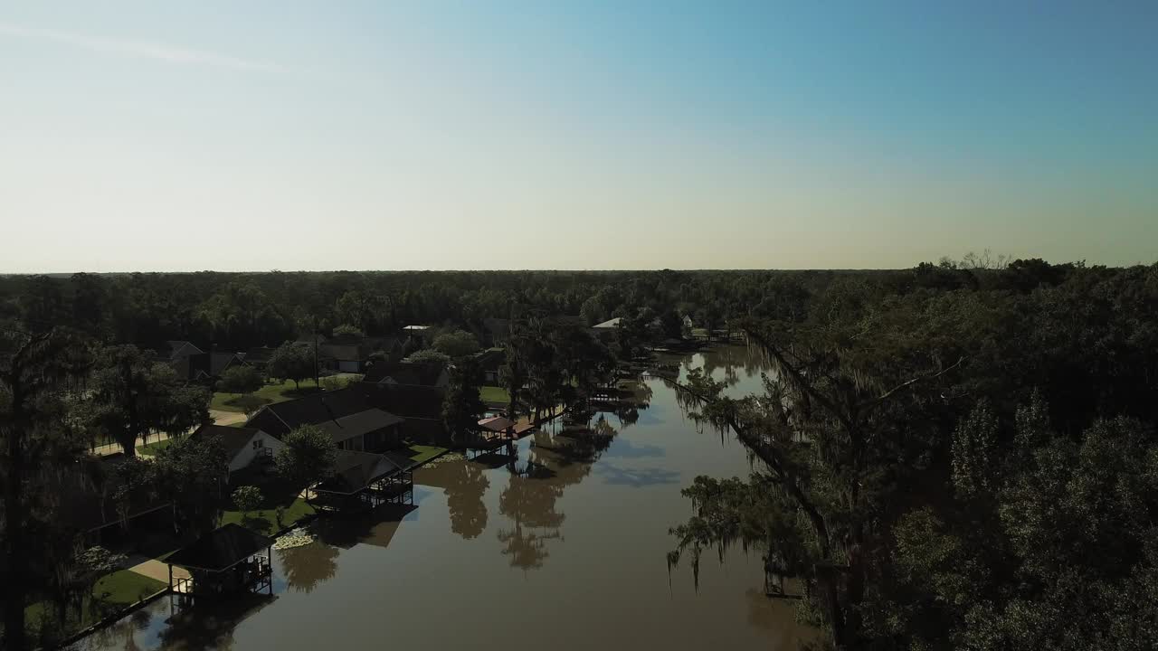 从空中俯瞰绿色景观上的房子，无人机在清澈的天空下以色利前进党在潺潺的小河上——小河远景，德克萨斯州视频下载