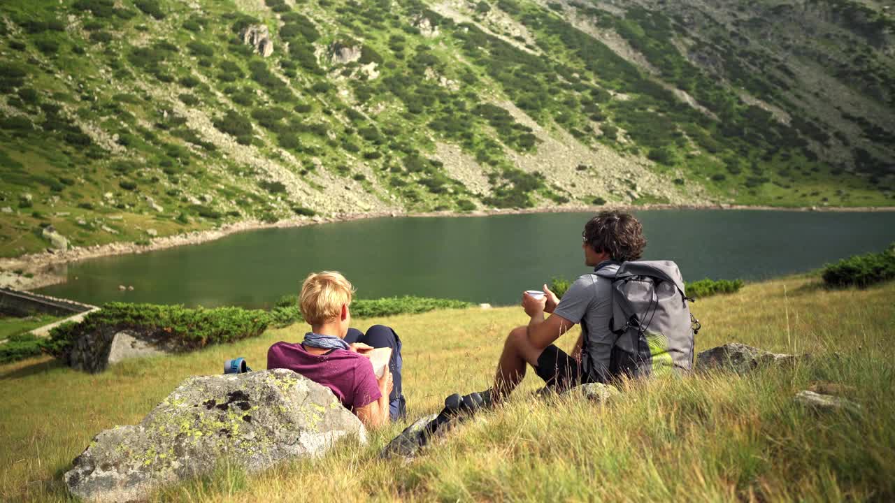 两个人坐在湖上的地上视频下载