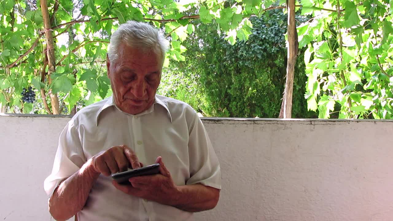 老人在户外使用数码平板电脑视频下载