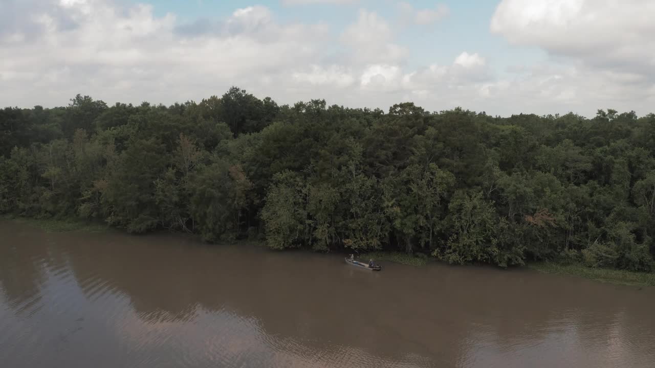 航拍拍摄的人在摩托艇上移动的波纹河，无人机飞过绿色的森林树木-河Vista，德克萨斯州视频下载
