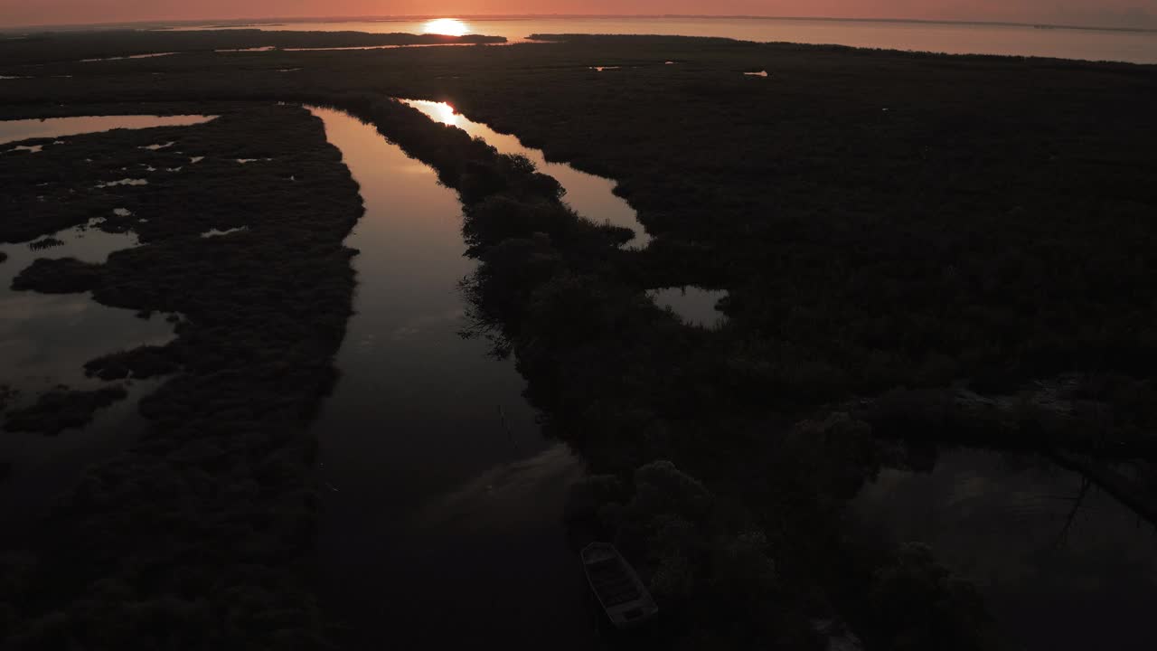 在荡漾的河流溪流上的植物的空中倾斜镜头，无人机在宁静的日落期间向后飞行- Bayou Vista，德克萨斯州视频下载