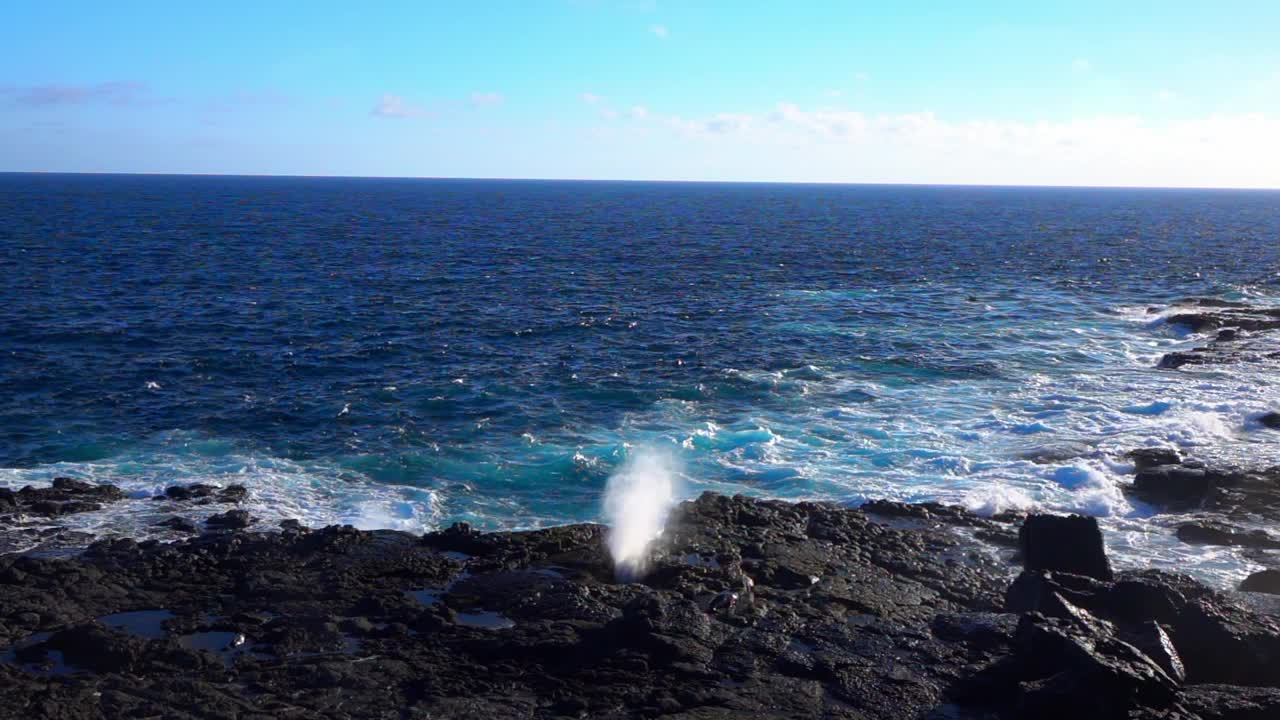 阳光明媚的一天，水从波涛汹涌的海面上的岩石中飞溅出来的慢动作锁定镜头——厄瓜多尔加拉帕戈斯群岛视频下载