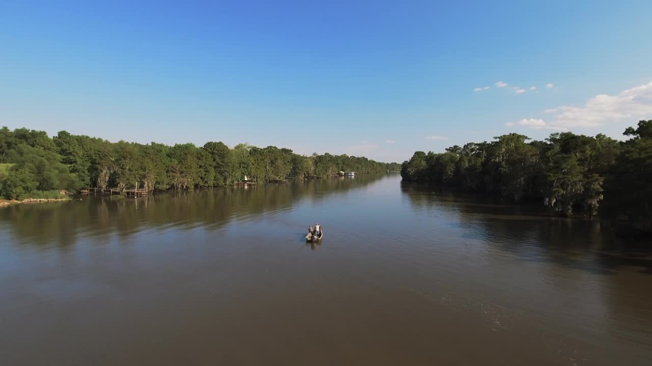航拍的人在摩托艇上移动的河在宁静的绿色森林，无人机在阳光明媚的日子里向后上升- Bayou Vista，德克萨斯州视频下载