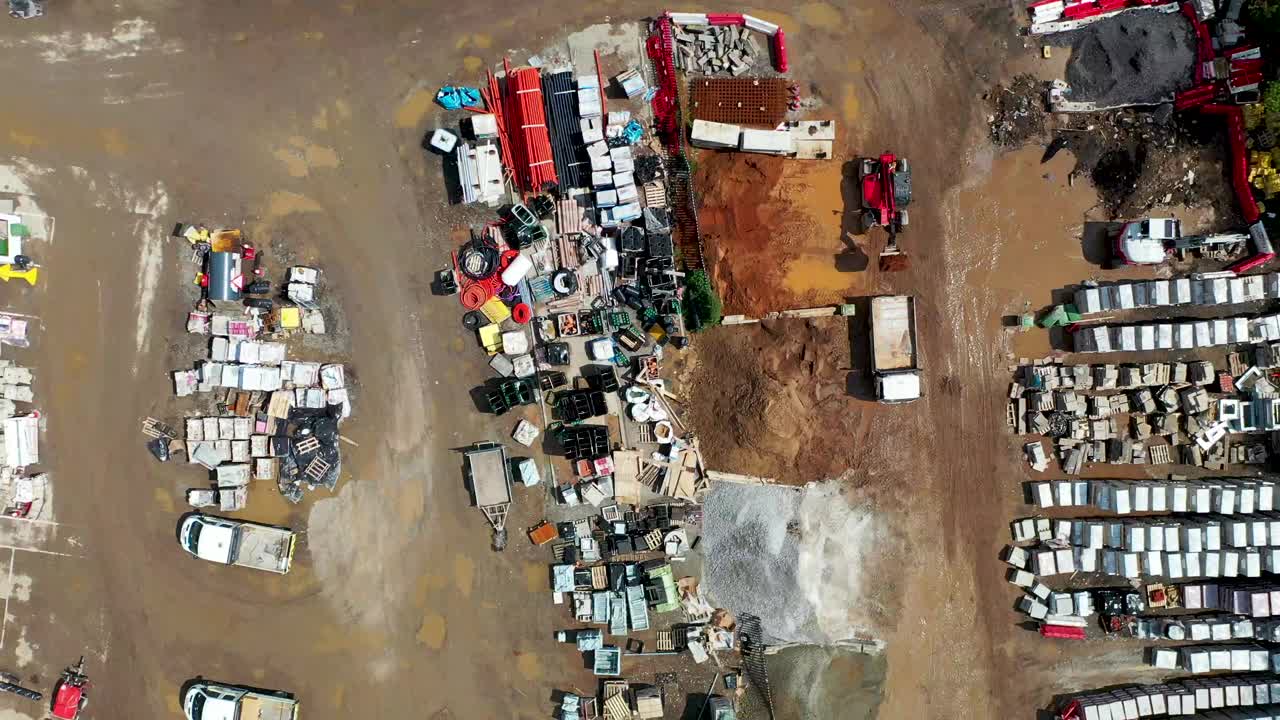 英国利兹市一个旧废料场和建筑商的航拍画面显示，一辆挖掘机正在装载一辆卡车，周围是建筑零件和废金属视频下载