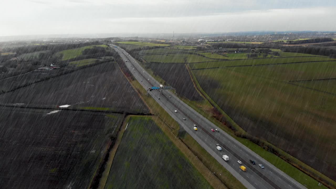 在暴风雨中拍摄的利兹西约克郡M62高速公路的狂风暴雨中的英国高速公路航拍画面视频下载