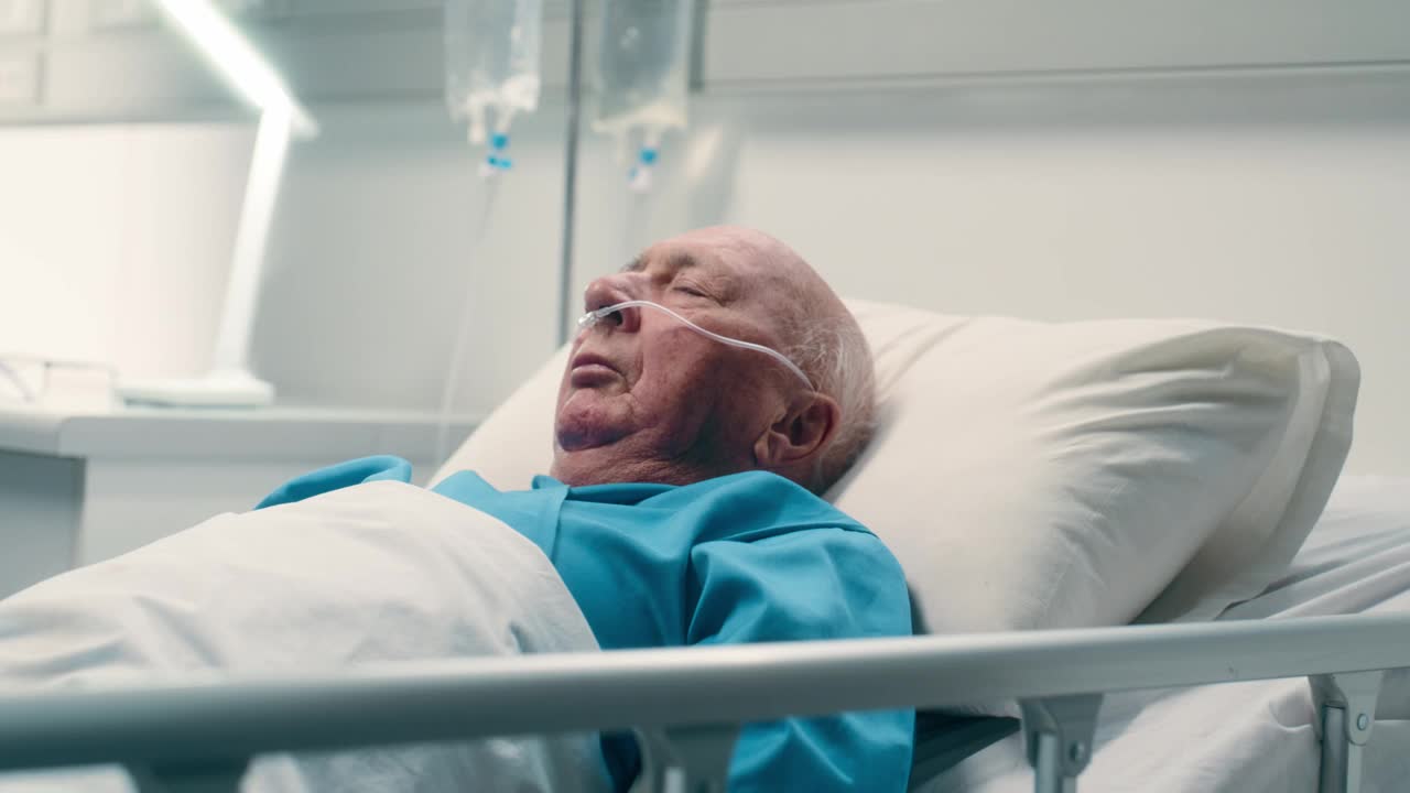 老人，在医院的床上睡觉，在诊所接受手术康复后发生事故。休息，恢复和病人在医疗帮助和呼吸管肺支持在ICU视频下载