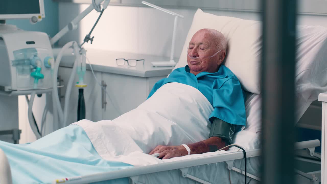 老人因手术康复躺在医院的病床上，因门诊事故而疲惫不堪。休息，恢复和病人在医疗帮助和呼吸管肺支持在ICU视频下载