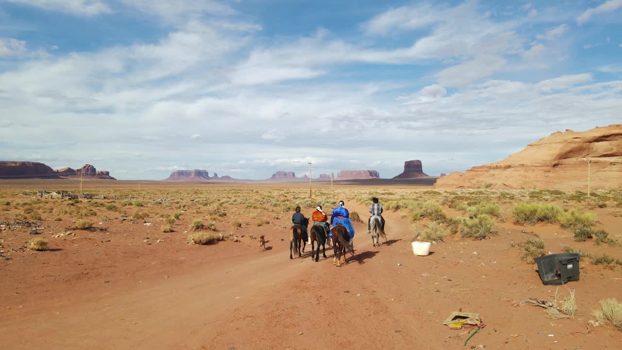 四个年轻的十几岁和更小的兄弟姐妹纳瓦霍印第安人骑着他们的马，在纪念碑谷部落公园附近的沙漠在夏季黄昏视频下载