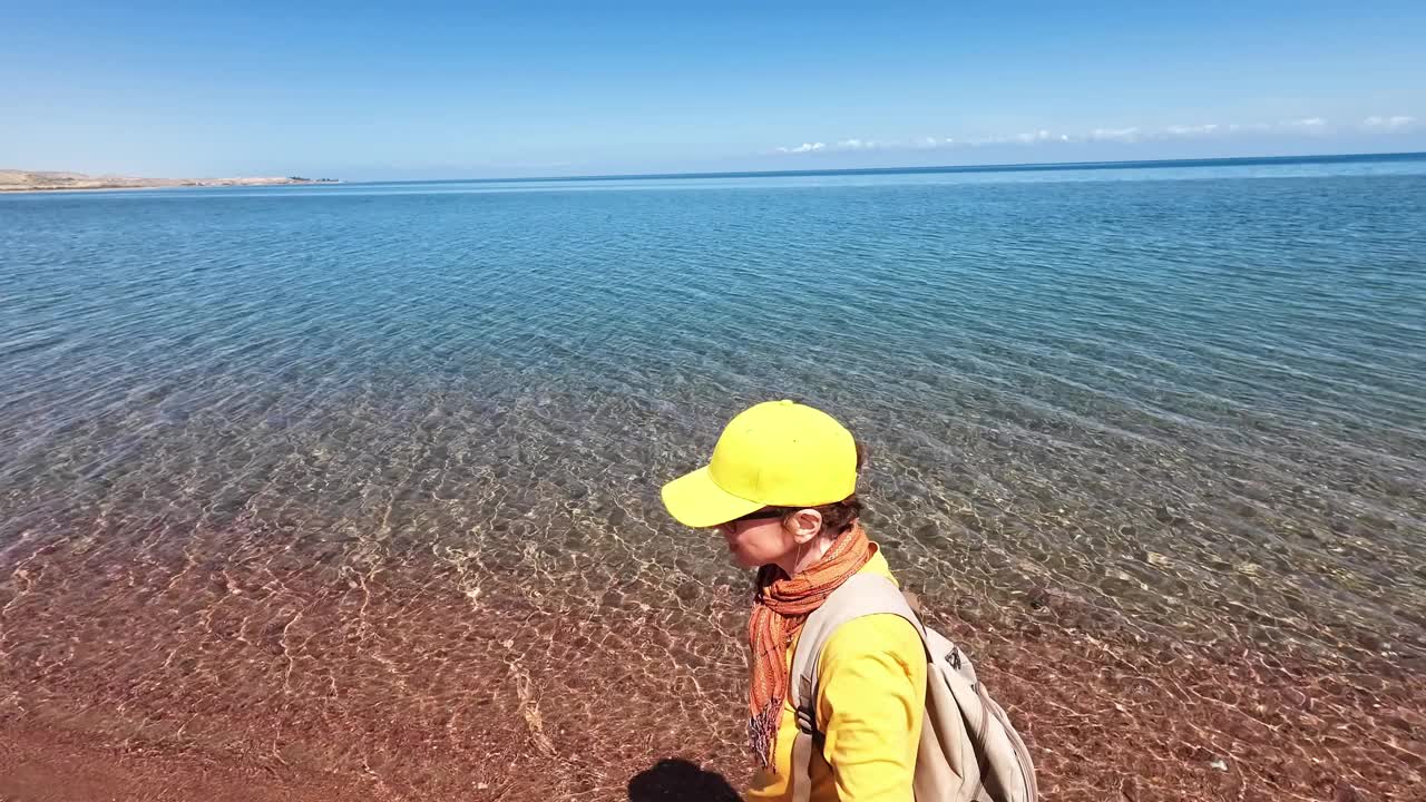微笑的女徒步旅行者在她探索的盐湖上拍摄视频视频下载