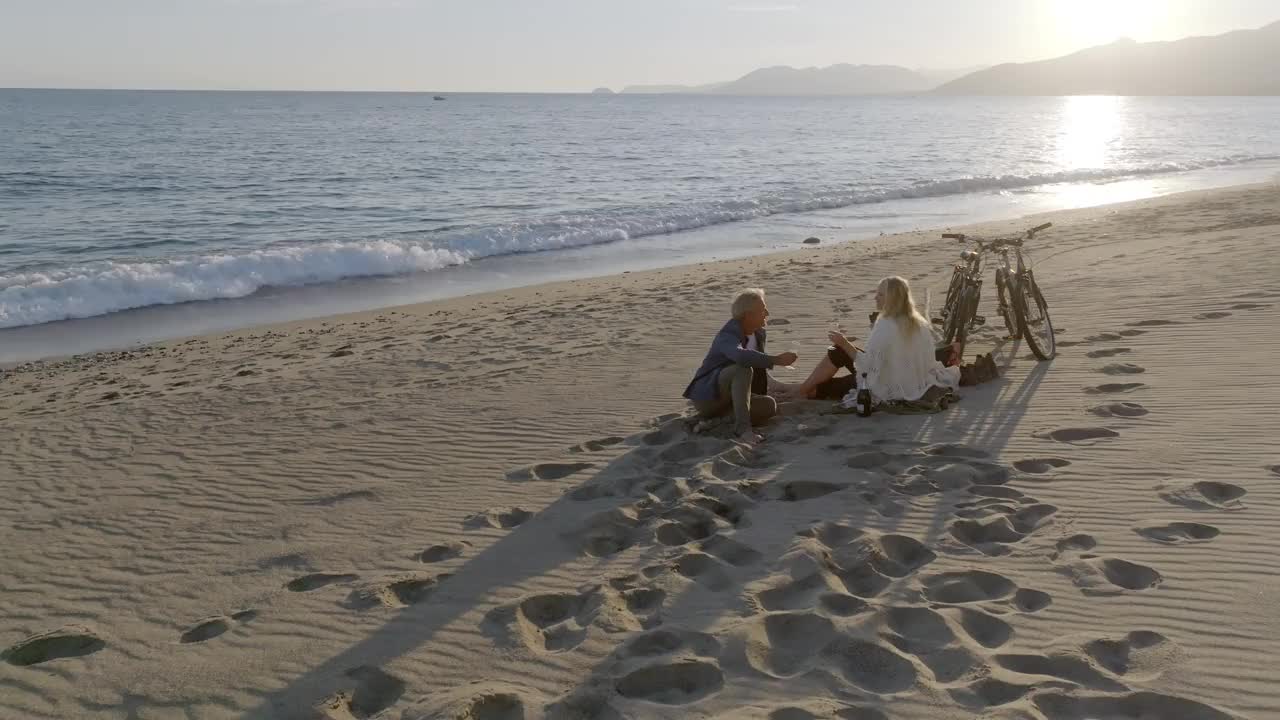 成熟夫妇在海滩上野餐的鸟瞰图视频下载