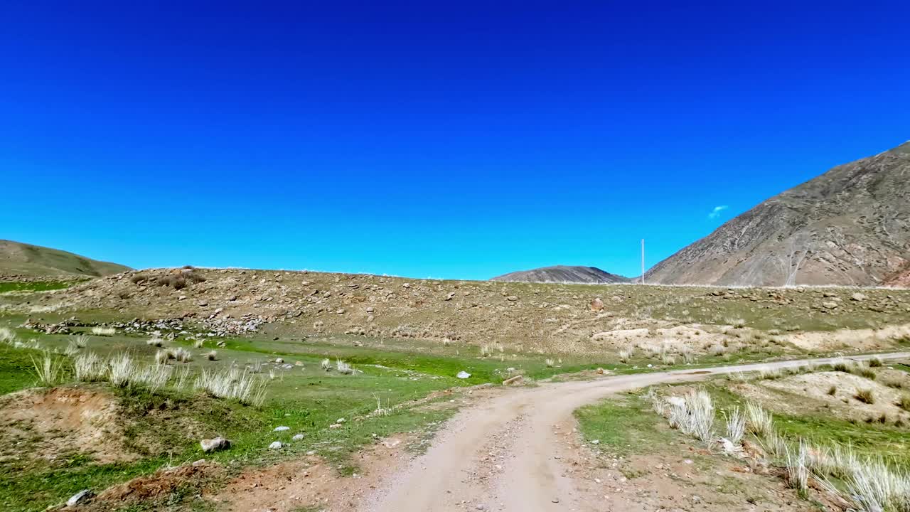 在高原山谷的春天景观中蜿蜒的沙路视频下载