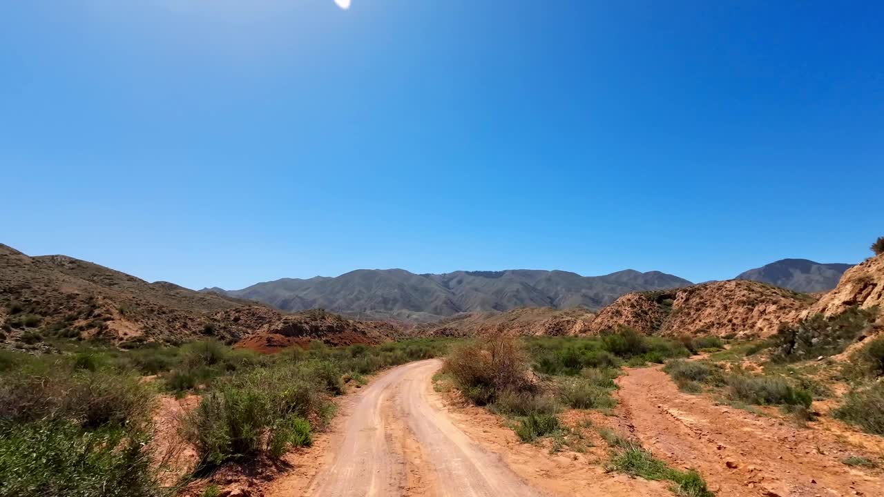 沿着一条蜿蜒的路线走向金色砂岩地层中的峡谷，与上方的蓝天形成对比视频下载