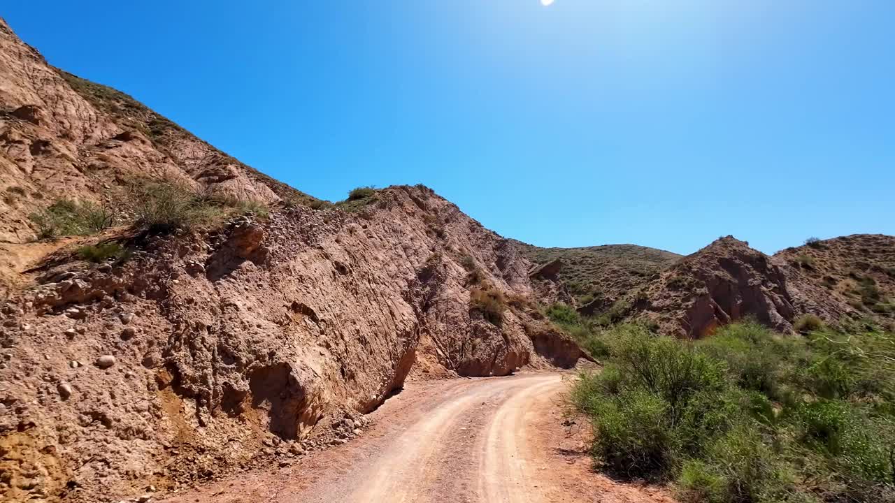 沿着一条弯曲的小路，穿过金色的砂岩岩层，走向峡谷，与蓝天和谐相处视频下载