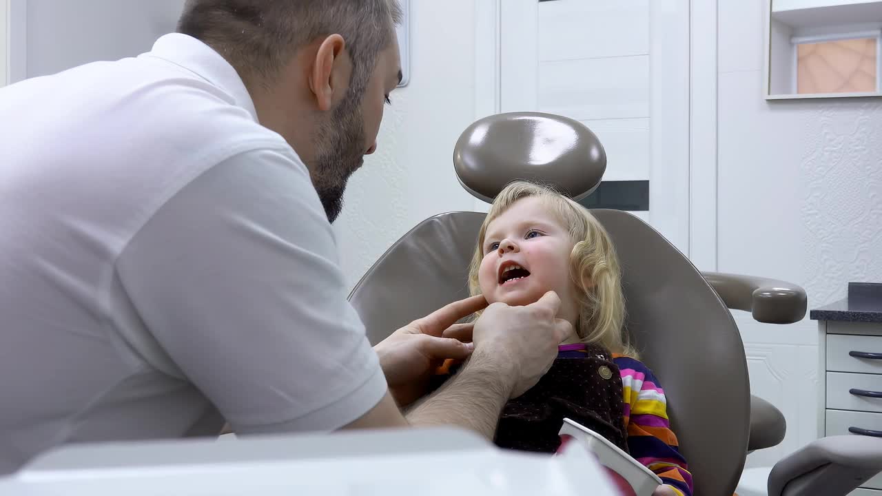 牙医正在检查一个小女孩病人的牙齿视频下载