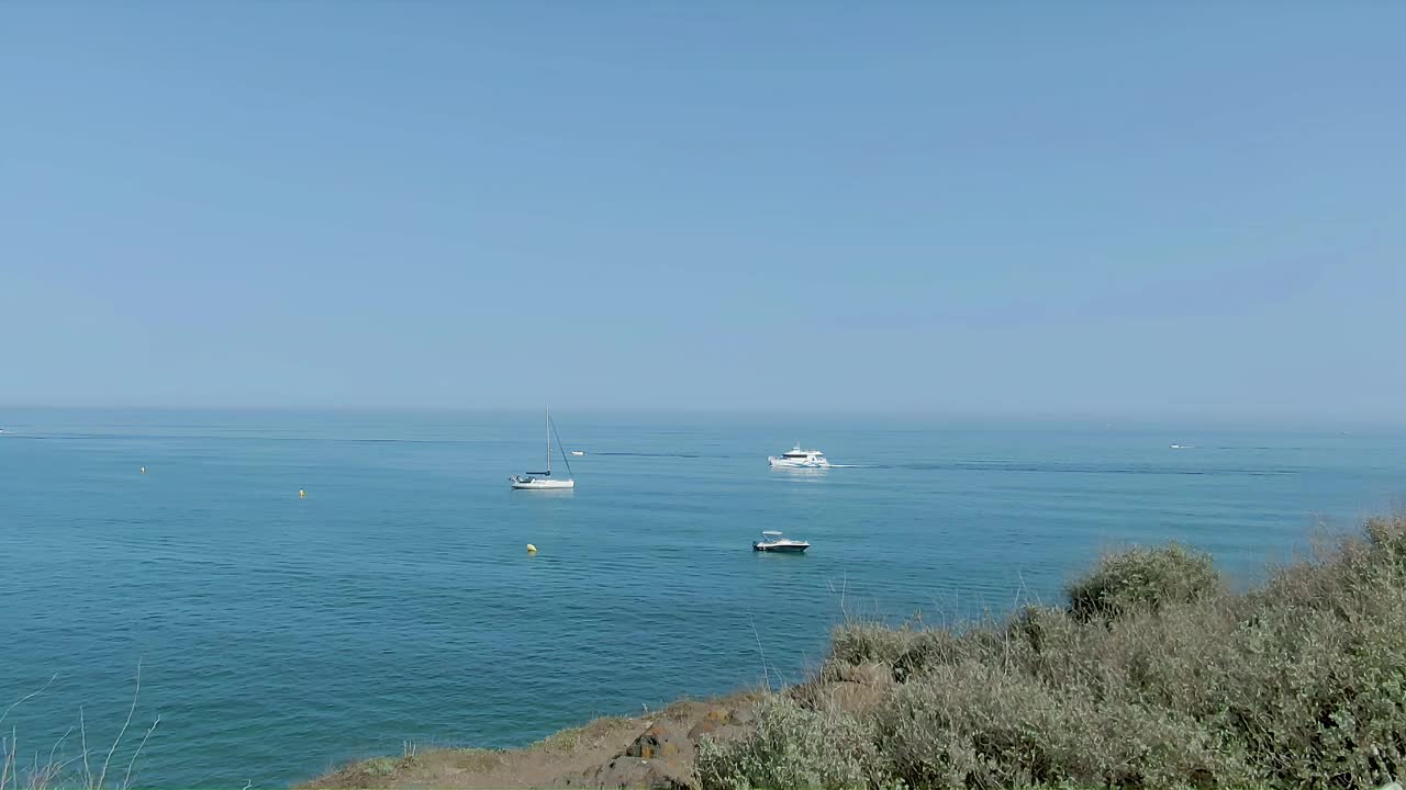 空中全景从悬崖到清澈的大海与船只在远处视频下载