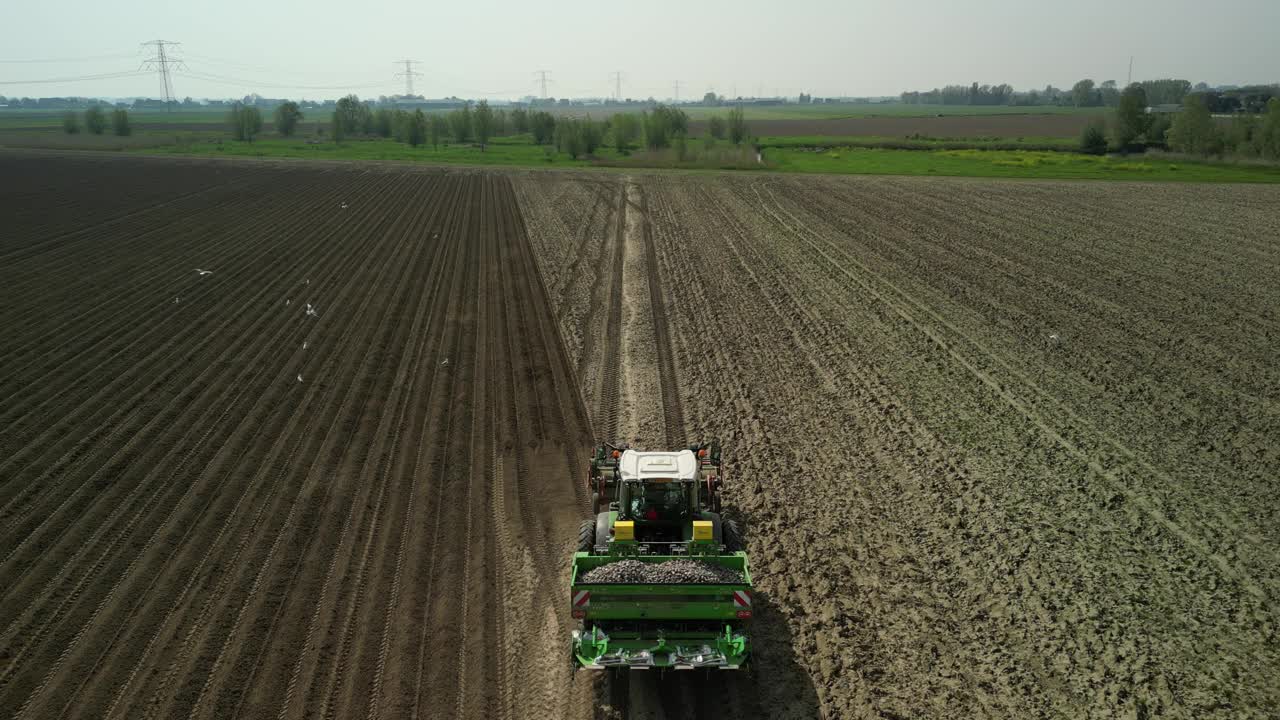 无人机拍摄的拖拉机在跑道上种植土豆的画面视频下载