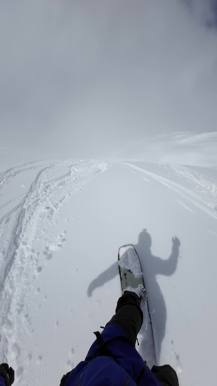 在偏僻的山区，在新鲜的雪粉上进行POV单板滑雪视频下载