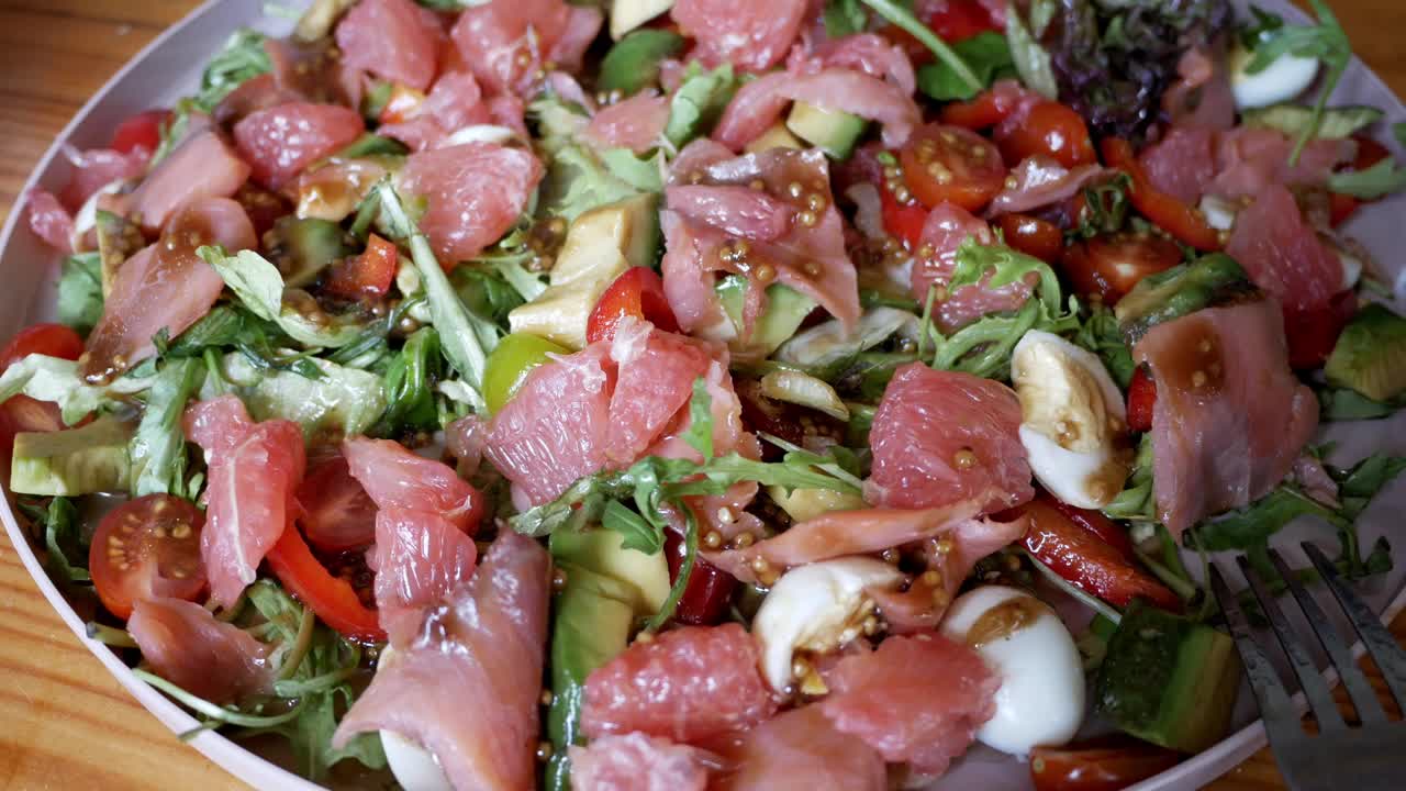 新鲜蔬菜沙拉配鲑鱼。芝麻菜，葡萄柚，圣女果，鹌鹑蛋，鳄梨。视频下载