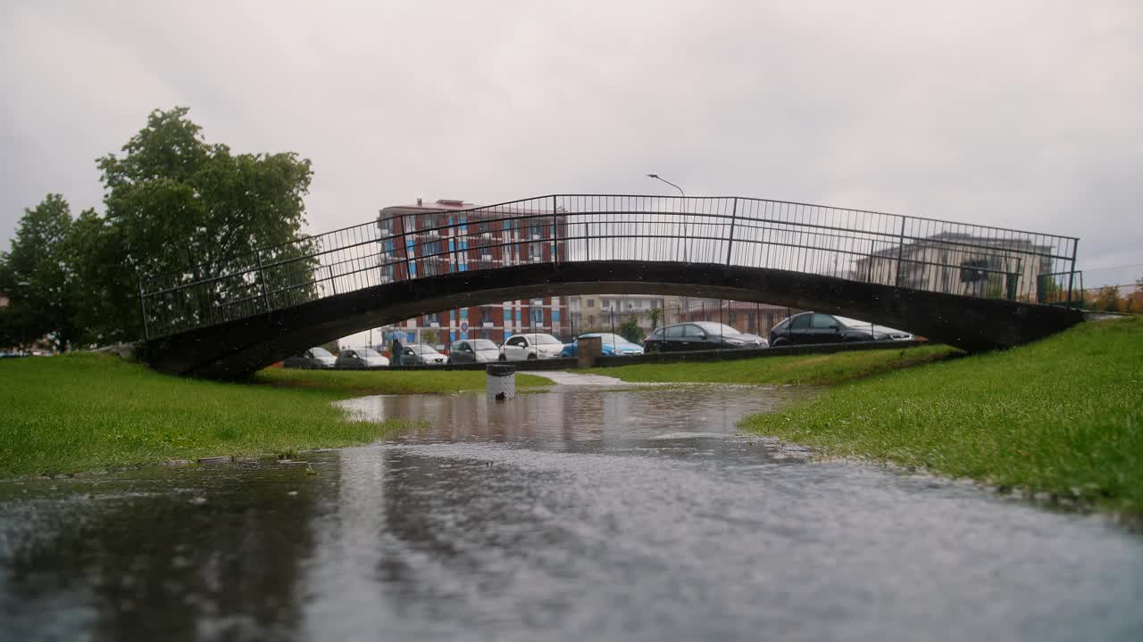 雨天的城市景观与水坑和拱桥的倒影视频下载