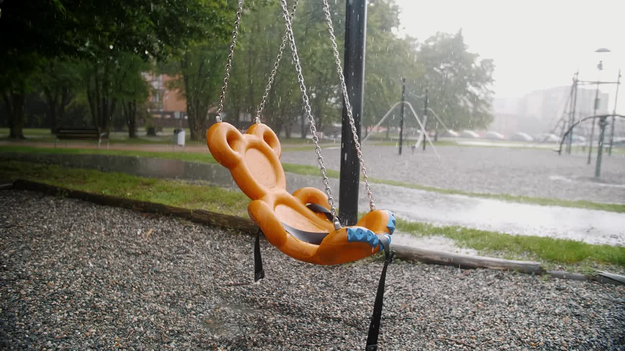 操场上的下雨天:安静的公园里空荡荡的秋千和潮湿的气氛视频下载