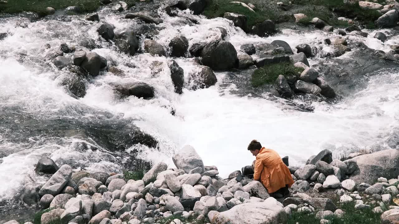女徒步者用运动相机拍摄山间溪流视频下载