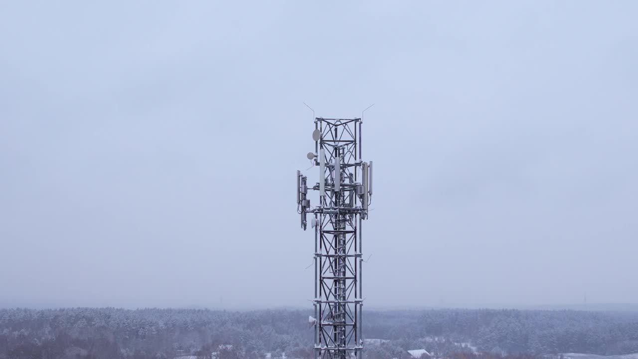 塔式天线电信手机鸟瞰图，蜂窝5g 4g手机无线电发射机。提供高速现代5g通信网服务。雪自然森林冬季。视频下载