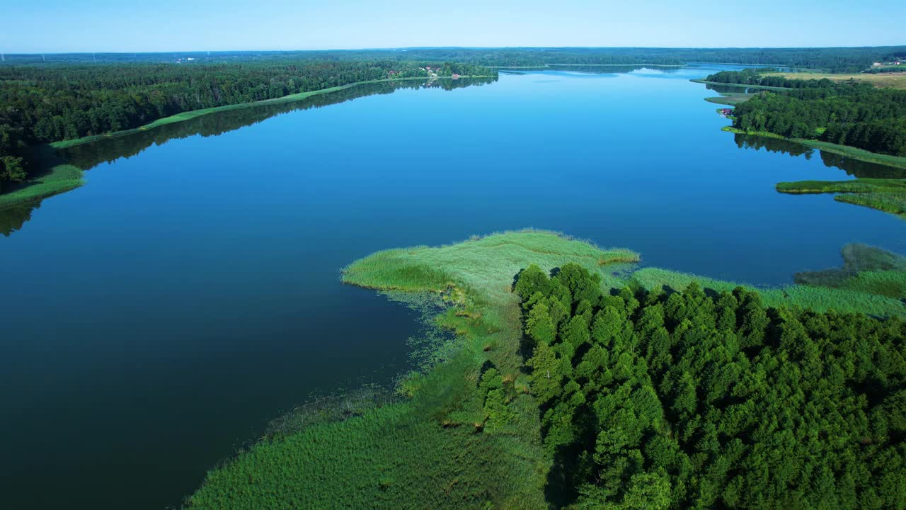 壮丽的鸟瞰平静的湖泊与岛屿在波兰。天堂湖岸边的乡村房屋。水面上的宁静。壮观美丽的湖鸟瞰图。史诗般的惊人的自然景观。视频下载