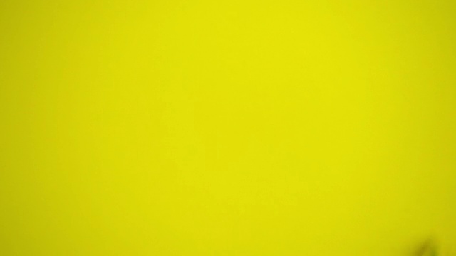 小女孩用黄色高清视频在白色墙壁上作画视频素材